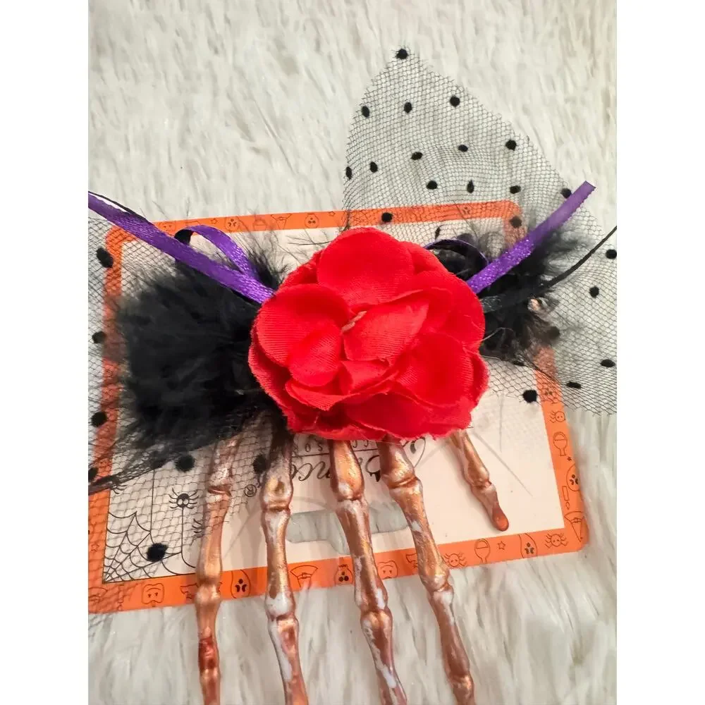 Red rose hair clip with black feathers and skeleton hand design